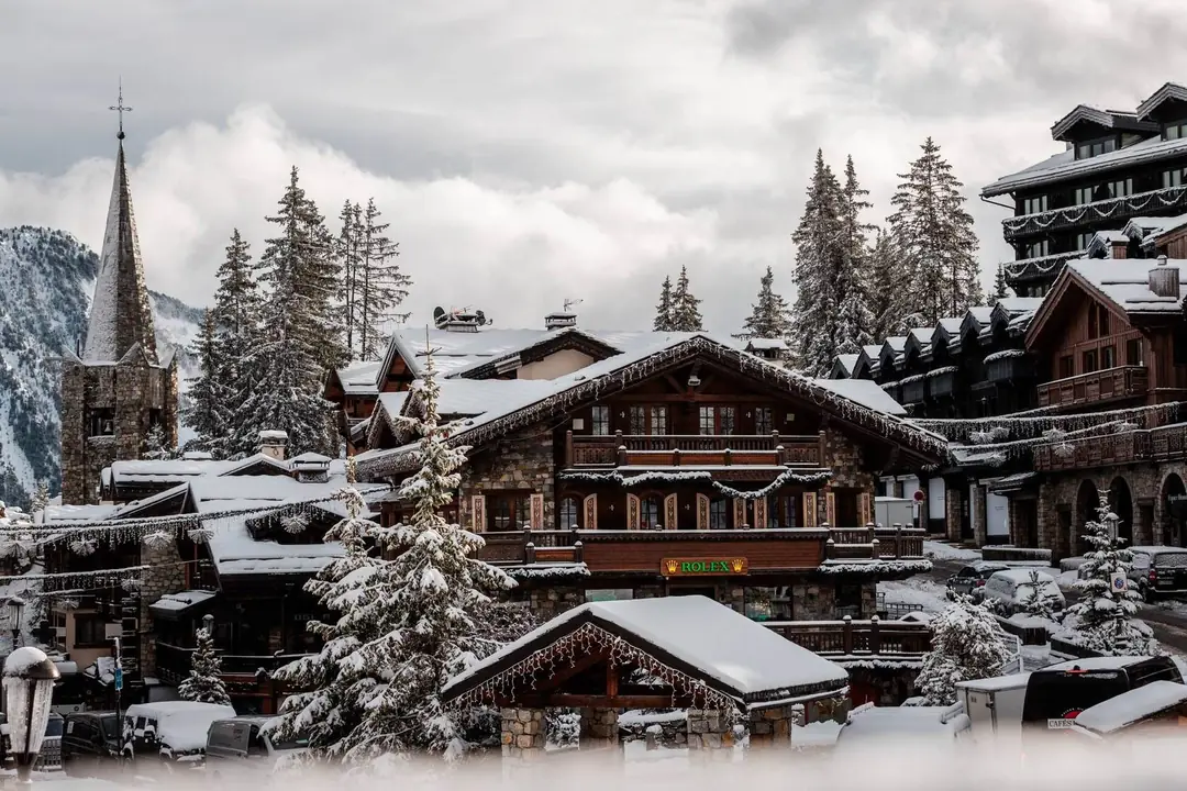Snow-covered chalets and church spire in Courchevel 1850 village, French Alps