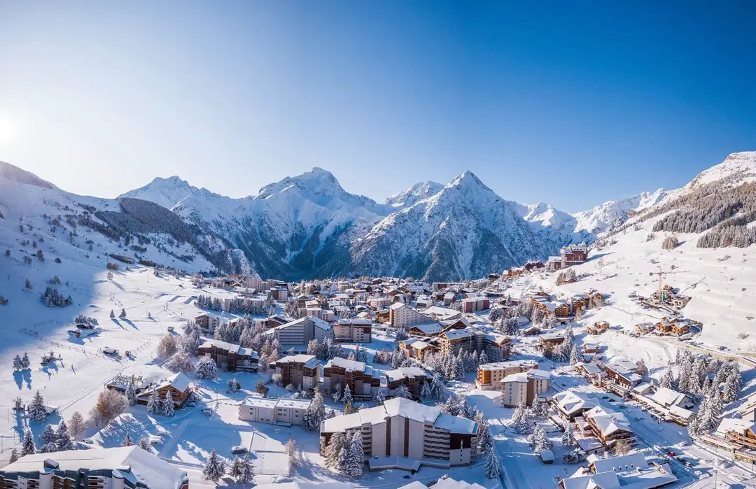 Aerial view of Les 2 Alpes ski resort under fresh snow below the Écrins peaks