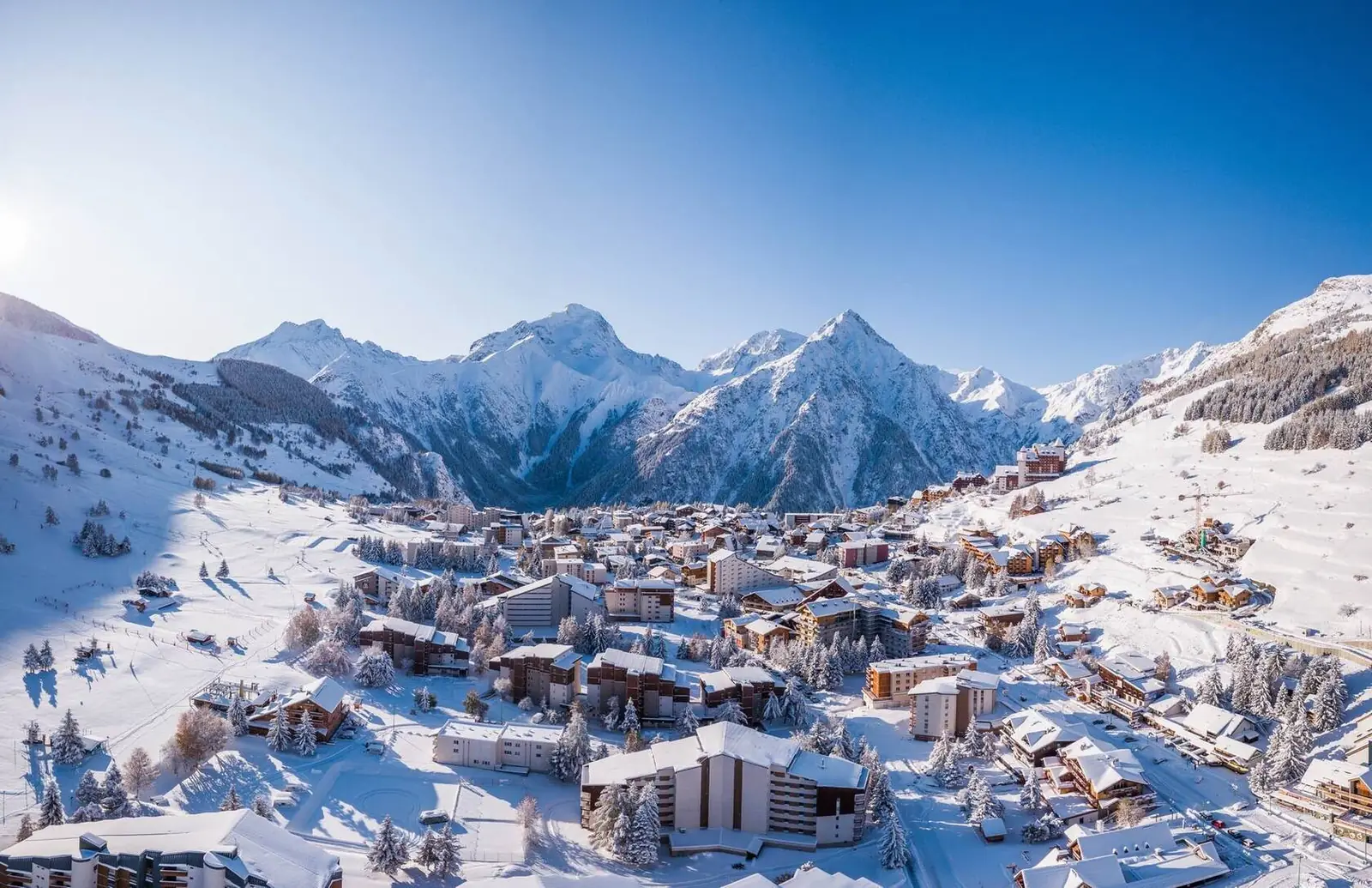 Aerial view of Les 2 Alpes ski resort under fresh snow below the Écrins peaks
