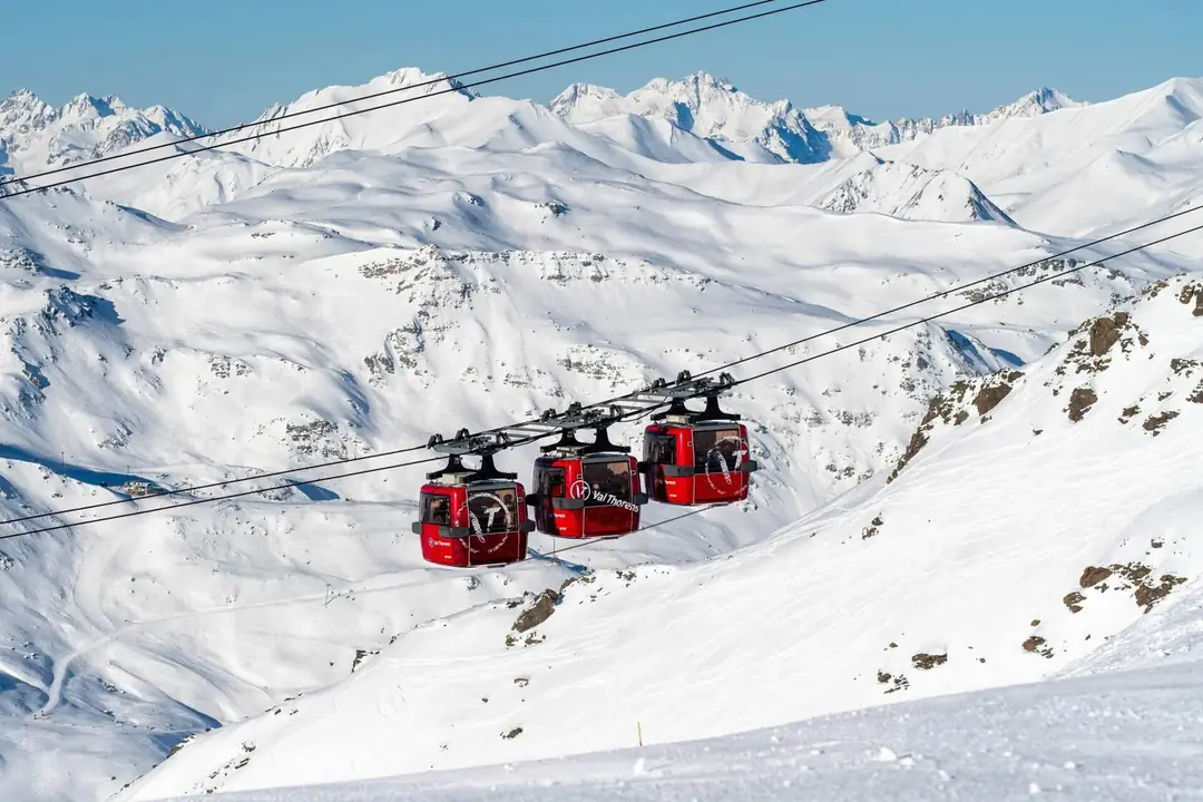 Red gondolas above the snowy peaks of Val Thorens, Les 3 Vallées